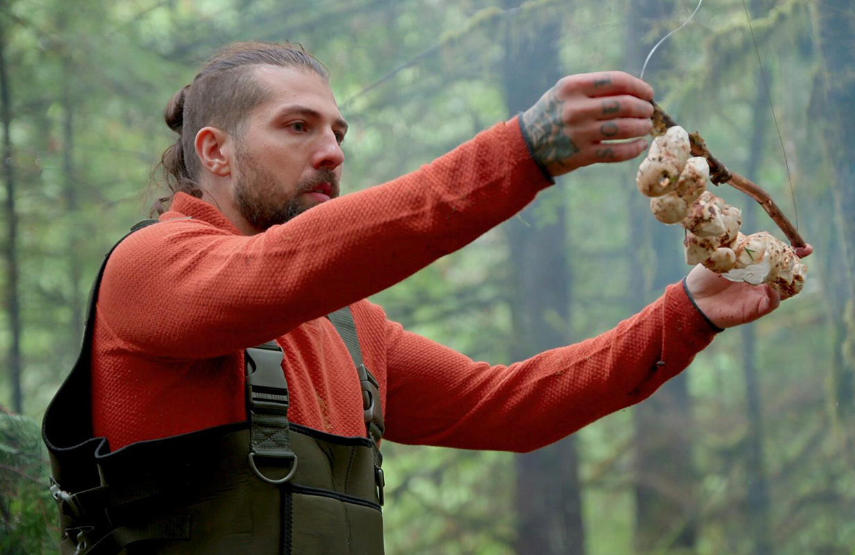 <i>Chefs vs. Wild</i> competitor Sammy Monsour dry ages mushrooms in the forest. (Photo: Hulu)