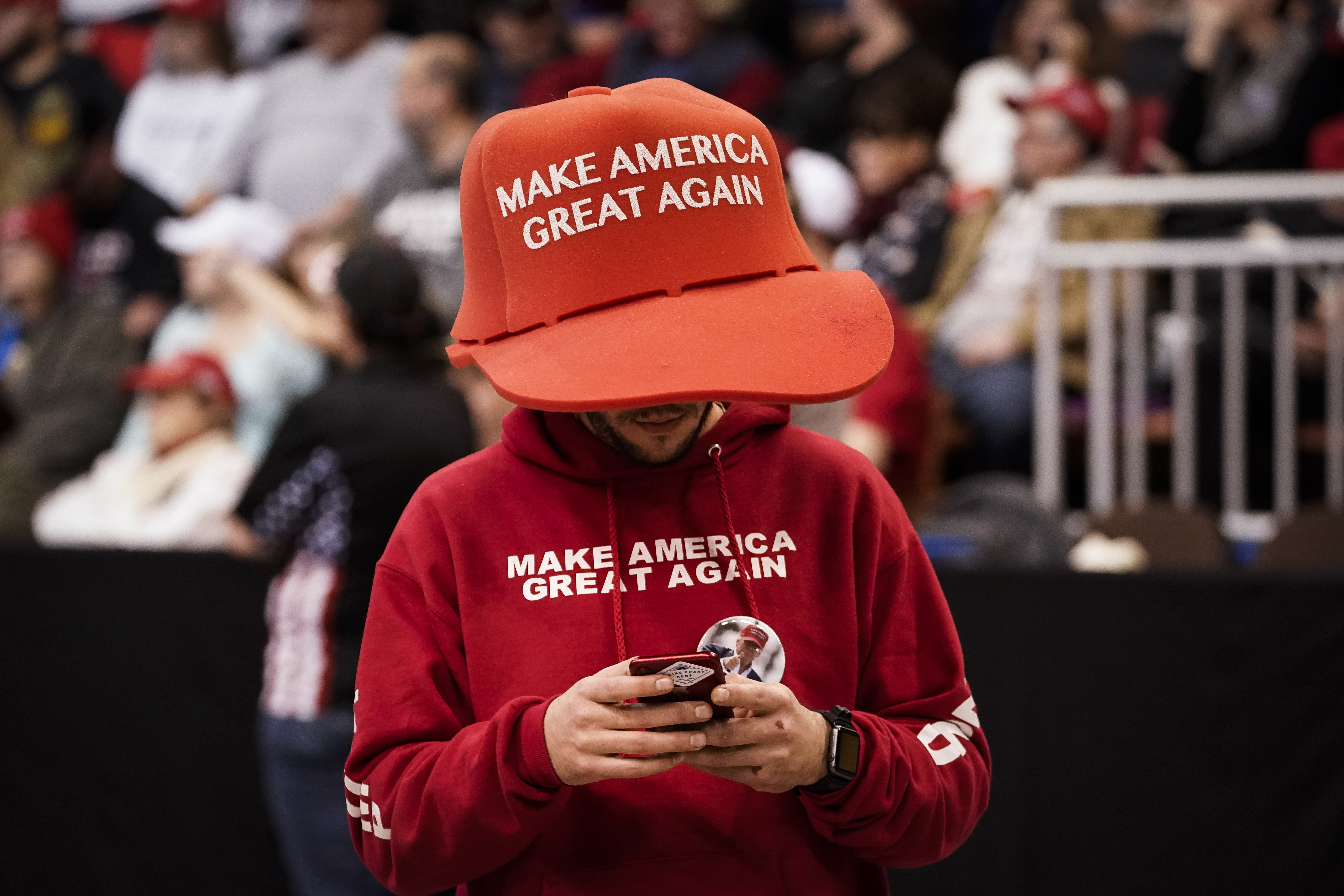 A Donald Trump supporter wearing an oversized Make America Great Again hat (Image via Getty)
