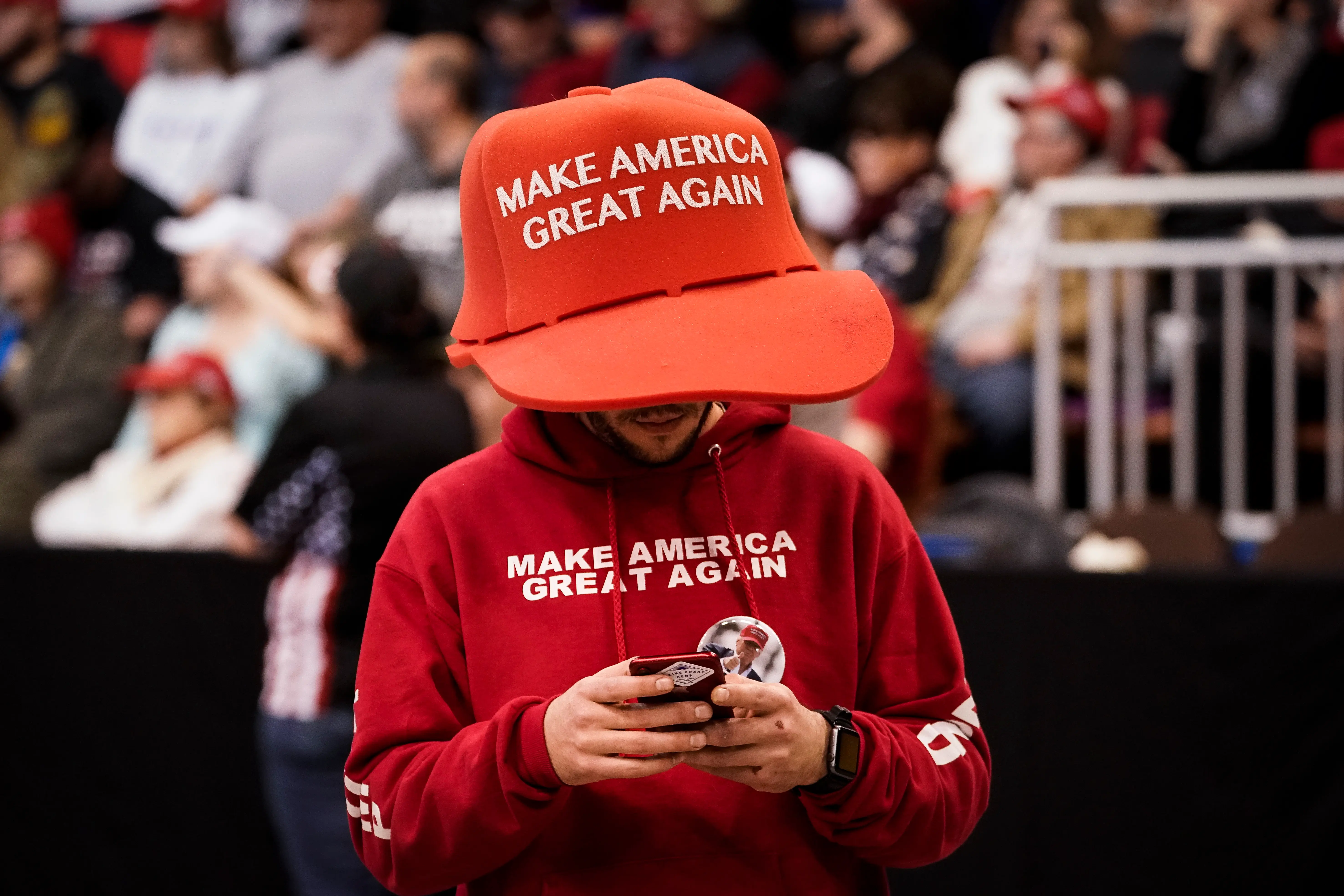 A Donald Trump supporter wearing an oversized Make America Great Again hat (Image via Getty)