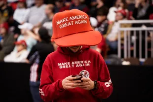 A Donald Trump supporter wearing an oversized Make America Great Again hat (Image via Getty)