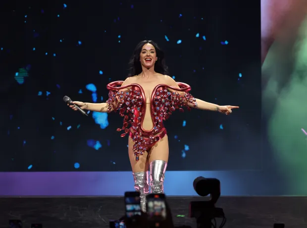 Katy Perry pauses her show to help a fan who collapsed while on stage during an emotional moment.